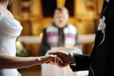 pareja-de-novios-frente-al-altar-como-organizar-una-boda