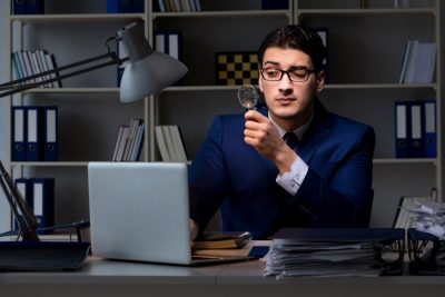 joven-oficinista-con-una-lupa-en-la-mano-leyendo-en-su-computador-consejos-financieros